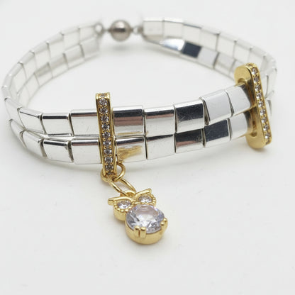 silver and gold tila bracelet featuring polished hematite beads and sparkling zircon details.